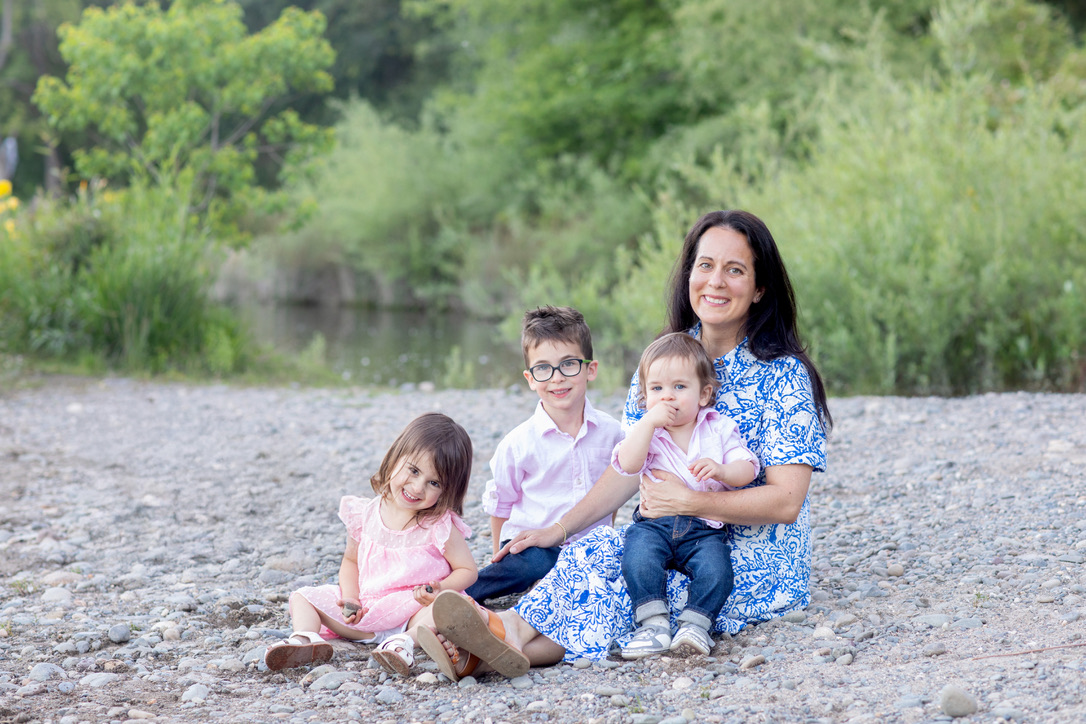 Lisa sitting by the river with her three littles